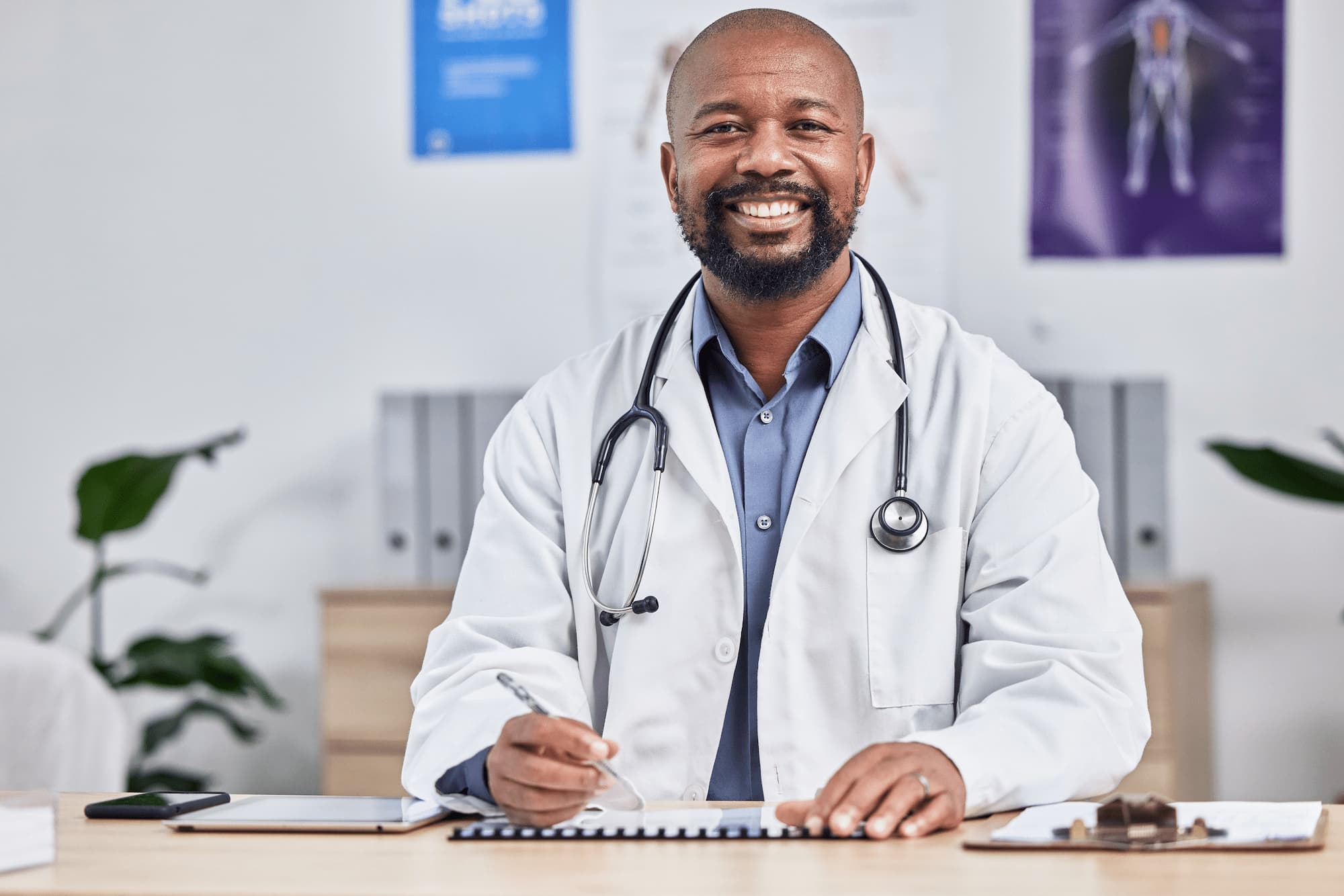 happy-smile-portrait-african-doctor-sitting-his-office-after-consultation-clinic-healthcare-professional-male-medical-worker-analyzing-results-medicare-hospital (1)