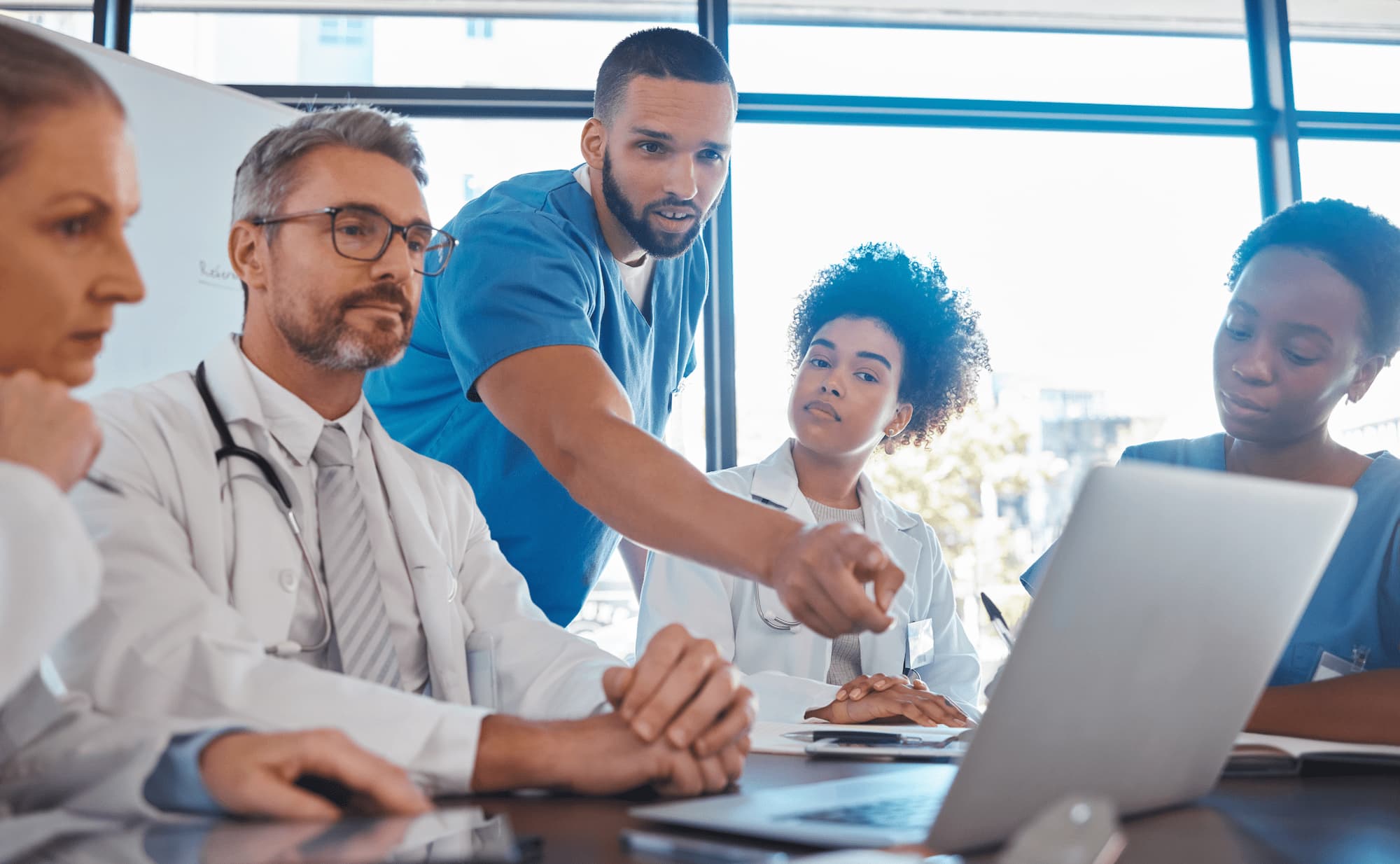 medical-meeting-laptop-team-office-discussion-brainstorming-planning-doctor-nurse-computer-desk-show-diversity-collaboration-teamwork-workshop-data-analytics (1)